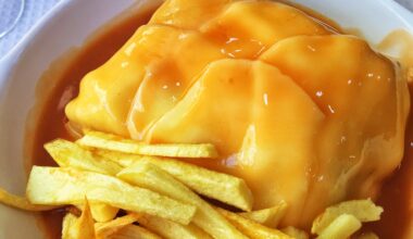Francesinha (Portugal) - technically a sandwich, with all kinds of deli meats, covered in cheese, an egg and accompanied by fries/crisps and hot sauce!