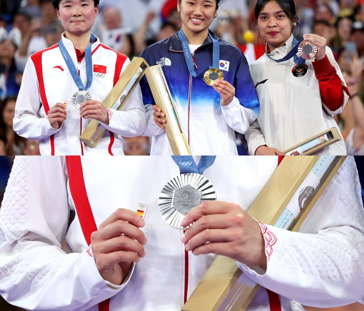 Chinese shuttler He Bingjiao carries Spanish flag badge onto the podium after her Spanish semifinal opponent's withdrawal due to injury