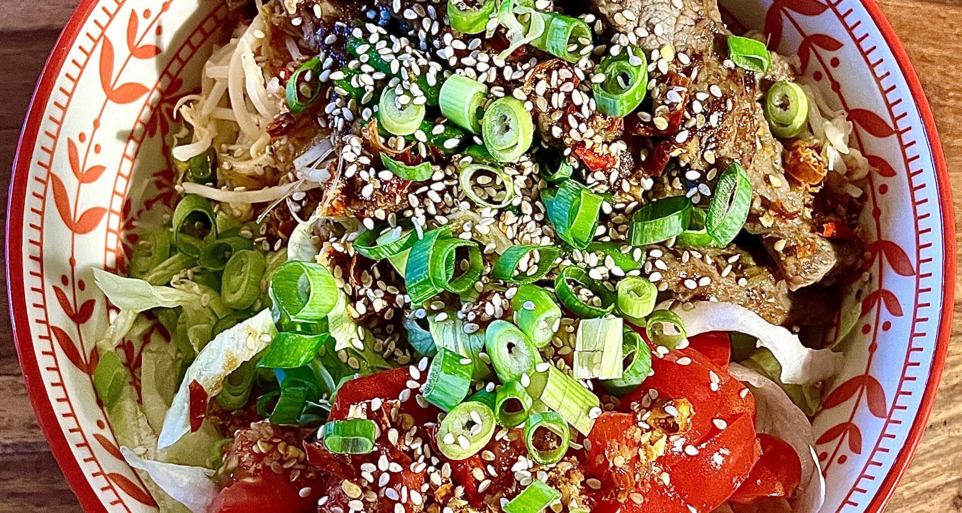 Homemade bowl with beef, rice noodles and chilli-ginger-lime sauce