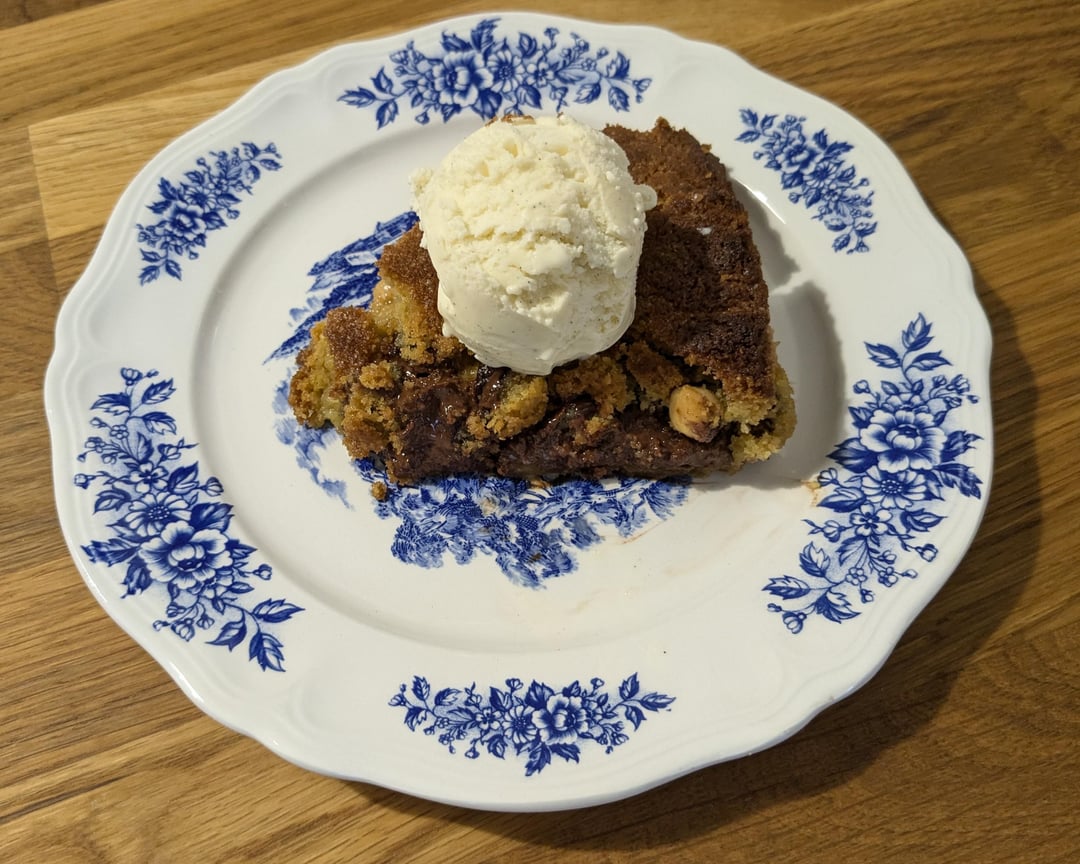 Cookie géant gianguja et noisettes grillées cuit dans une poêle en fonte