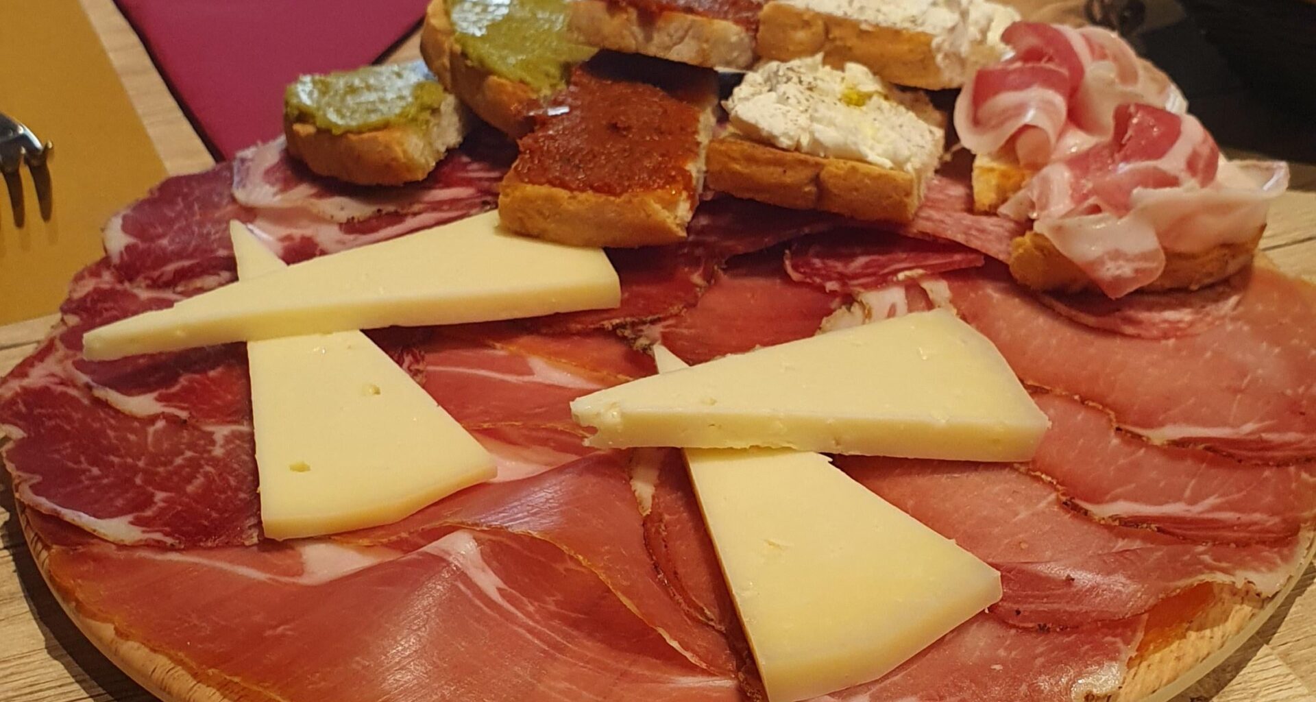 An appetizer with local cheese, salami and bruschette
