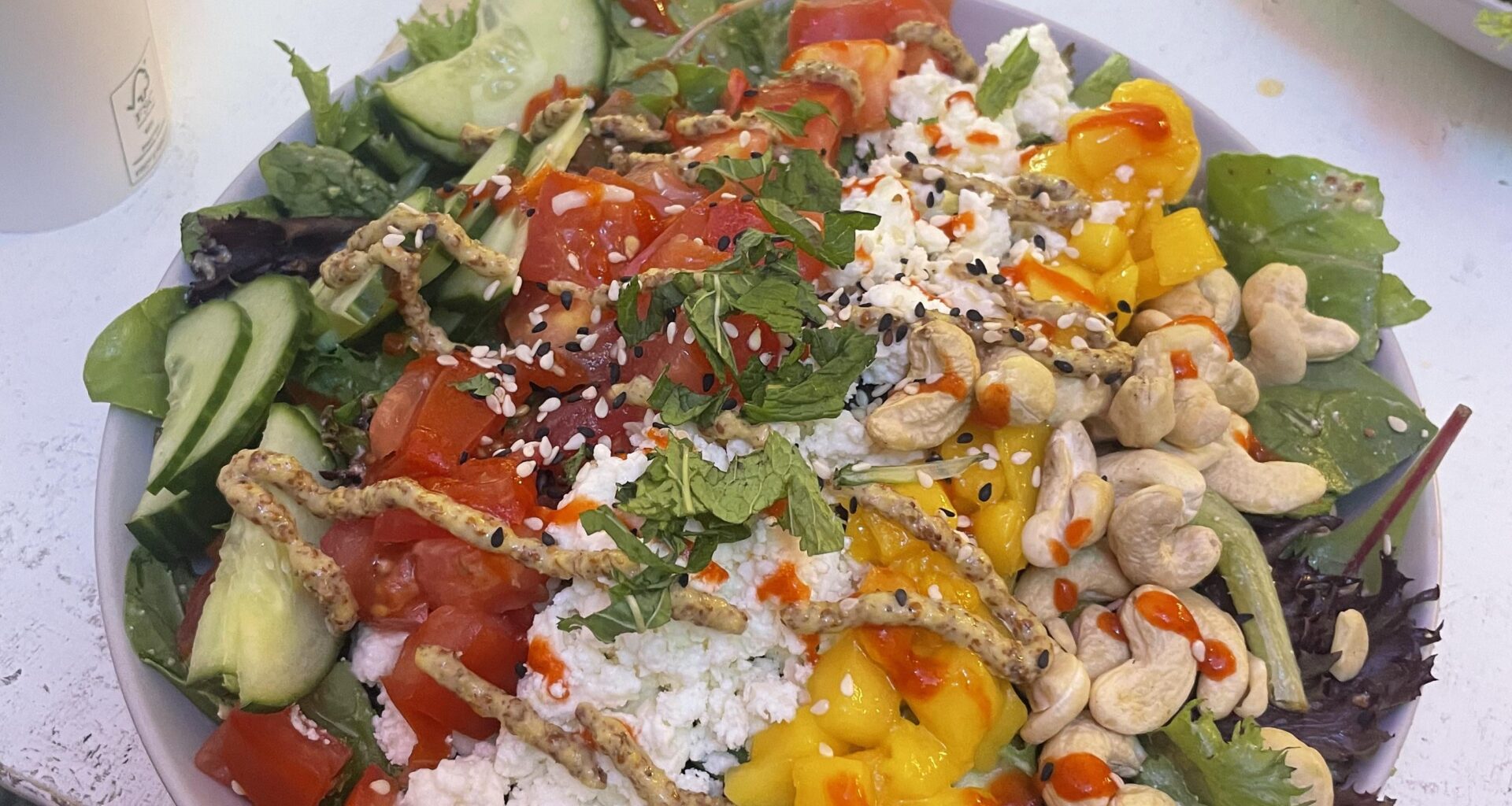 Salad with cucumber, tomato, feta, mango, and cashews