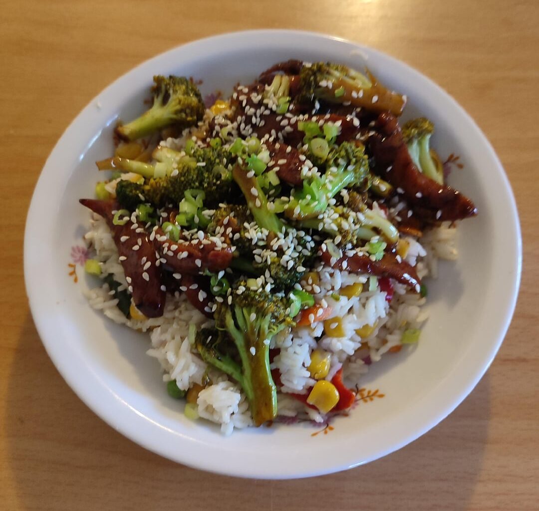 Stir fried broccoli and sausage over rice and veggies