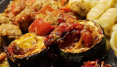Meatballs from row pork sausage, at a spicy and creamy sauce, with fried courgettes and pasta