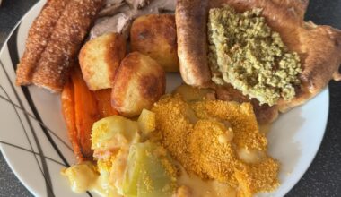 Roast pork dinner with Yorkshire pudding, cauliflower cheese, honey roasted carrots, stuffing and roast potatoes
