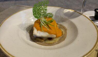 Oven-cooked cod filet with a black garlic cream, romesca (tomato-based Catalonian sauce) gratin, and potatoes.