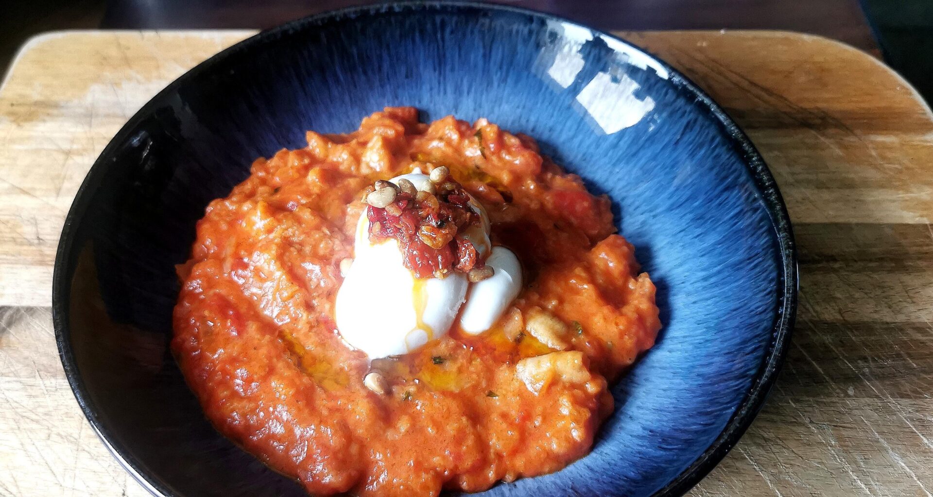 Pappa al pomodoro with basil oil, toatsed pine nuts and burrata