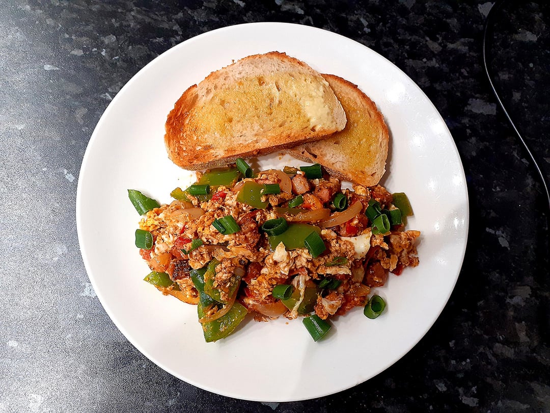 Scrambled eggs with bacon, onion, peppers and tomatoes