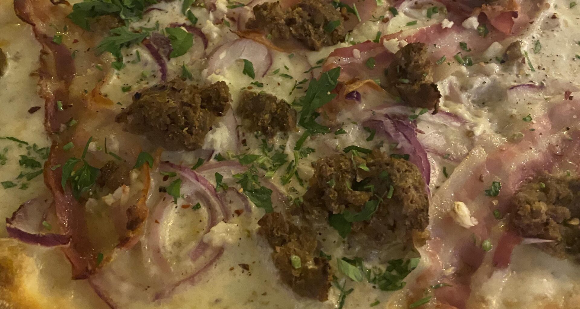 loosely based on flammkuchen - flatbread with white truffle cream base, mozzarella, pancetta, garlic, onion, sausage & herbs