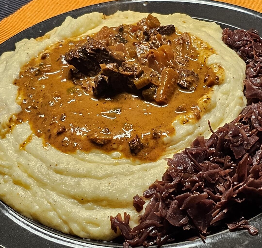 Stew with vegetables and beef cubes from the leg, with freshly prepared mashed potatoes and preserved red cabbage from last season