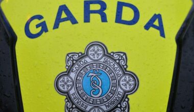 Garda Siochana logo seen on an escort. It's outside and raining.