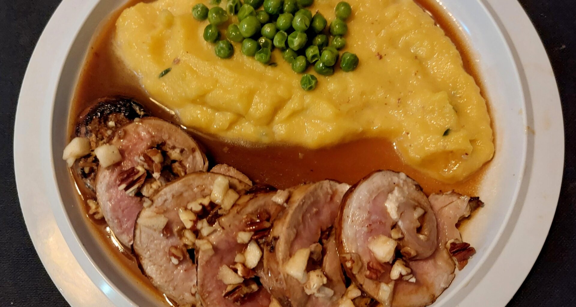 Pork loin roll, stuffed with goat cheese, apple, pecans and apple syrup. With pumpkin mash and a cider jus.