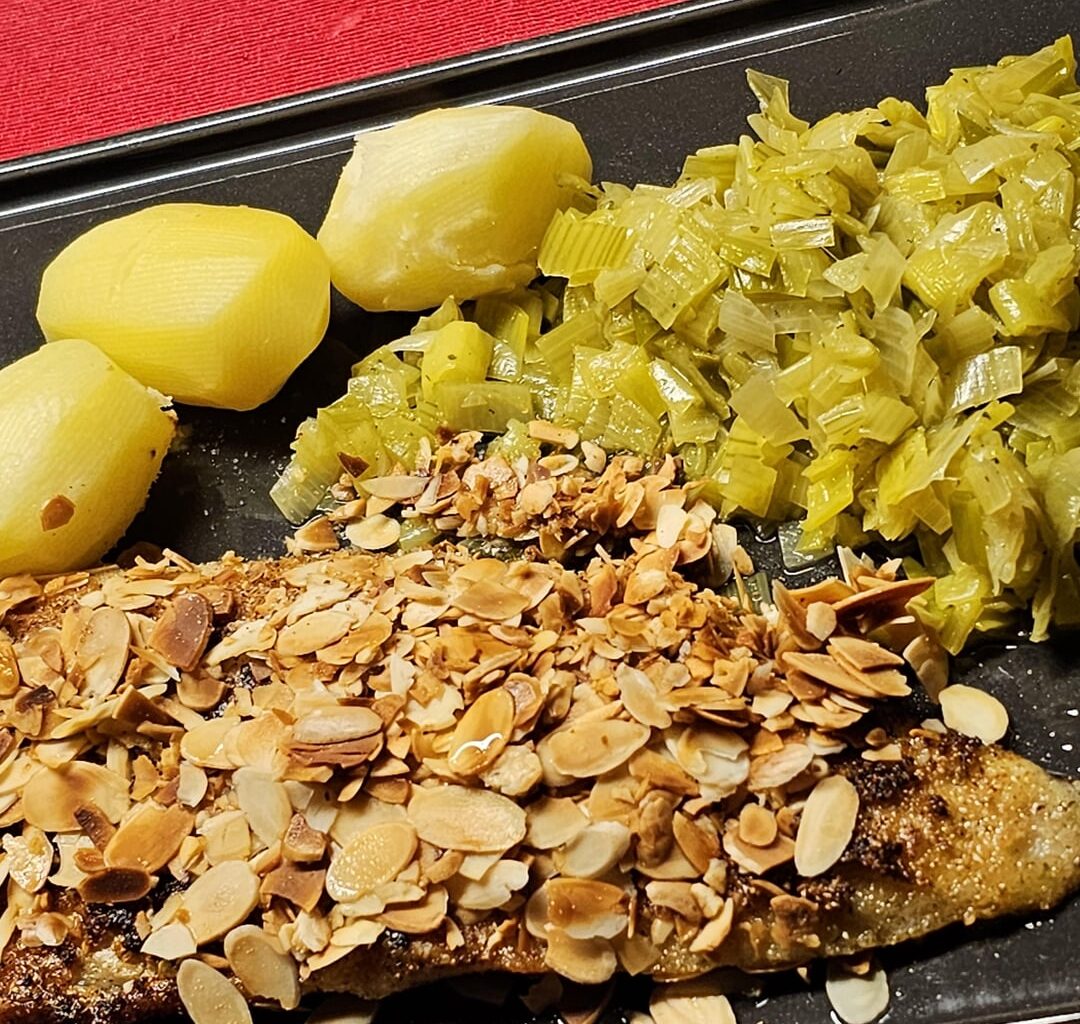 Zander fillet with freshly roasted almonds, boiled potatoes and leeks cooked in a white wine sauce