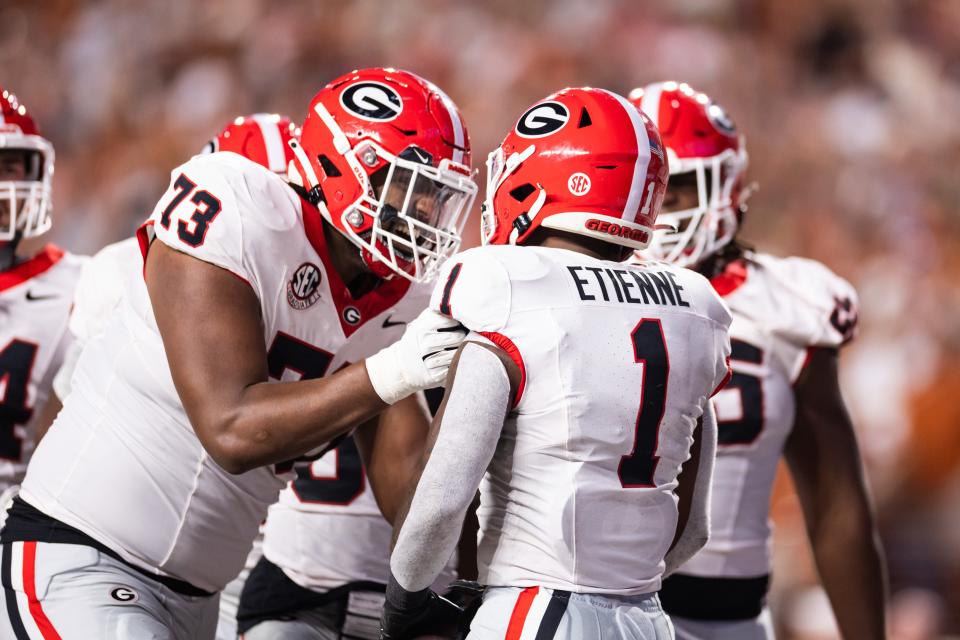 Oct 19, 2024; Austin, Texas, USA; Georgia Bulldogs running back Trevor Etienne (1) celebrates with offensive lineman Xavier Truss (73) after scoring a touchdown against the Texas Longhorns during the second quarter at Darrell K Royal-Texas Memorial Stadium. Mandatory Credit: Brett Patzke-Imagn Images