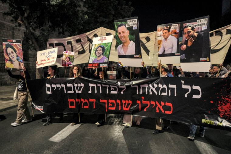 Des Israéliens portant des portraits d'otages retenus à Gaza appellent leur gouvernement à agir pour leur libération, lors d'une manifestation devant la résidence du Premier ministre Benjamin Netanyahu à Jérusalem, le 24 octobre 2024 ( AFP / Ahmad GHARABLI )
