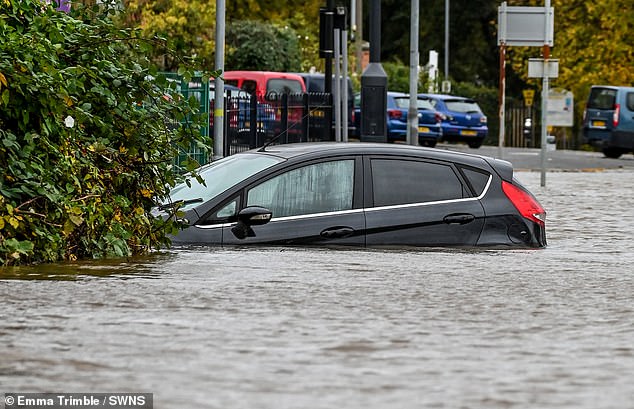 The River Severn has burst its banks causing flooding in Worcester. Here a car stuck on Pitchcroft Carpark is swamped up to its wing mirrors  on October 20