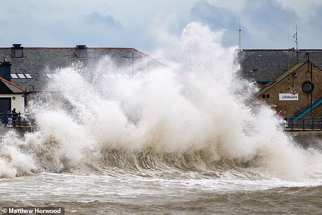 Waves crash against the harbour wall in Porthcawl, Wales. Met Office meteorologist Dan Stroud said 'very strong, severe gales' on Sunday coincide with high spring tides, which could also result in 'very large waves'