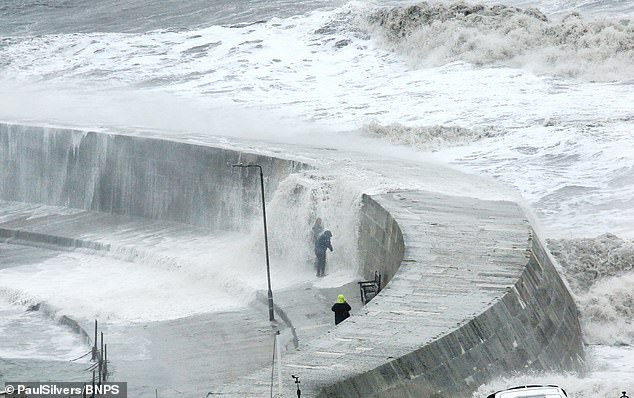 Pictured: Thrill seekers get caught out by a freak wave hitting the Cobb at Lyme Regis on October 20