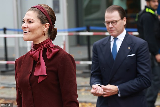 She sported a pair of dangly gold and jewel earrings and wore her hair brushed back in an elegant chignon for the occasion