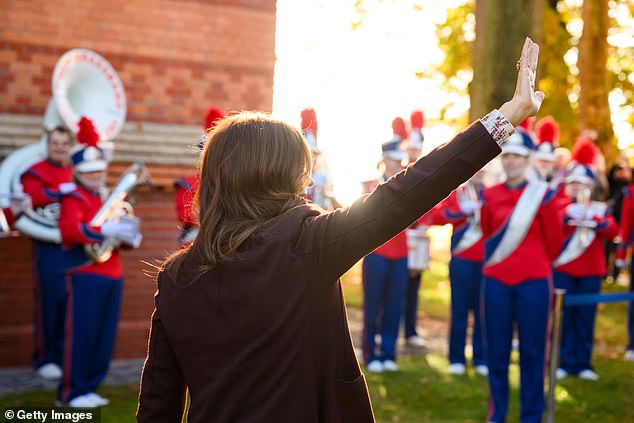 Queen Mary waves to the crowd as a marching band plays to welcome her to Kiel, Germany