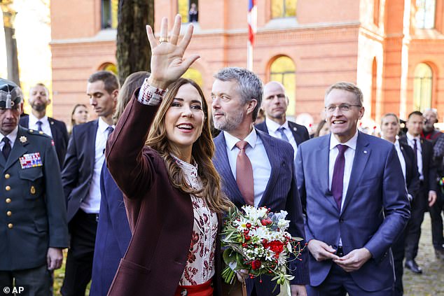 The Queen accepts a bouquet of German chamomile, thistles, rose hip and red berries from the crowd