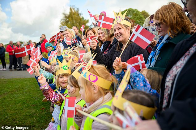 Small children wearing paper crowns and waving Danish flags lined Mary and Frederik's route