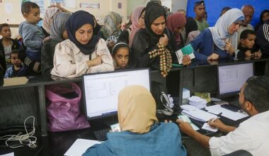 Palestinians wait in a queue at a UNRWA clinic in Deir-al-Balah to receive medication and medical treatment