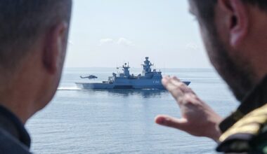 German Chancellor Olaf Scholz speaks with a serviceman as he stands aboard the frigate Mecklenburg-Vorpommern during his visit of the German Navy during a military maneuver in the Baltic Sea near Rostock-Warnemünde, northeastern Germany