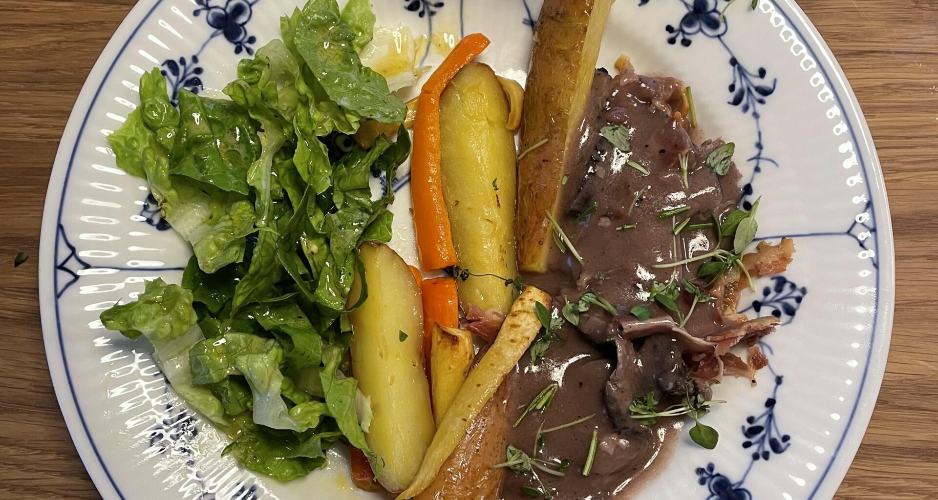 Venison in a red wine sauce with root vegetables and a basic salad