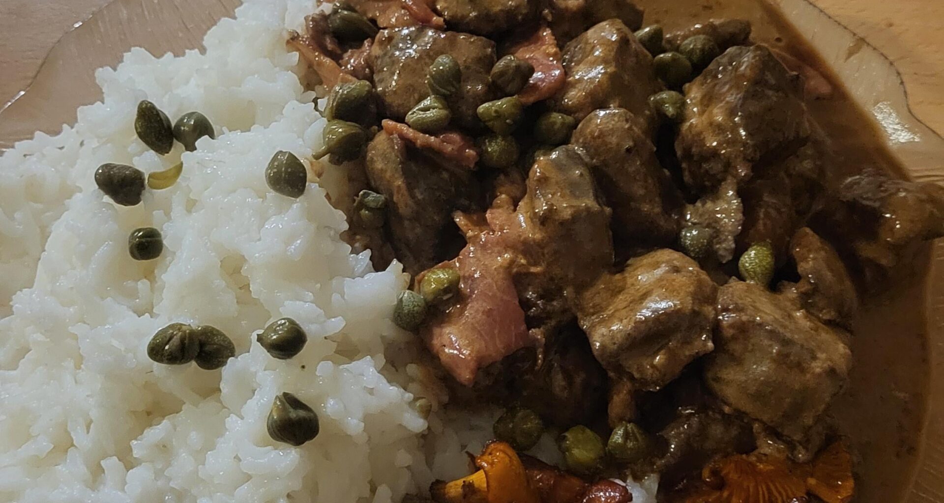 Moose calf liver stewed in cream with bacon and some cognac, served with rice, butterfried chanterelle mushrooms, and some capers.