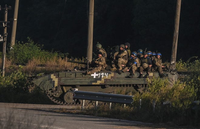Ukrainian army fighters sit on the top of an armed vehicle in Kharkiv on Sept. 9, 2022, amid Russian invasion of Ukraine.