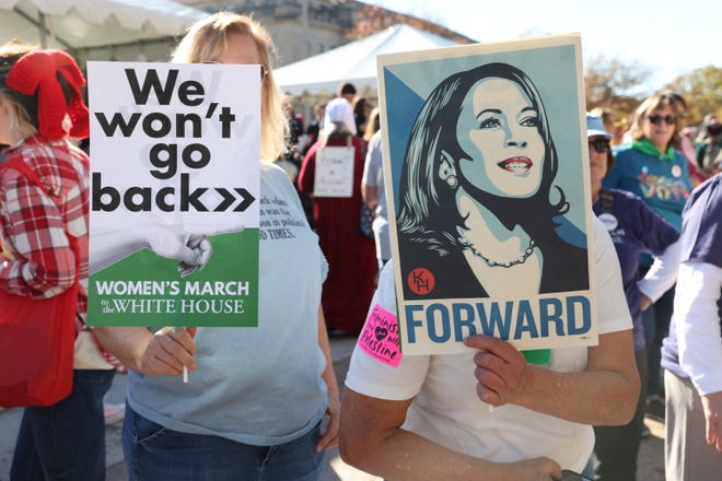 Demonstrators hold signs as they participate in the National Women's March in Washington, D.C., on Nov. 2, 2024.