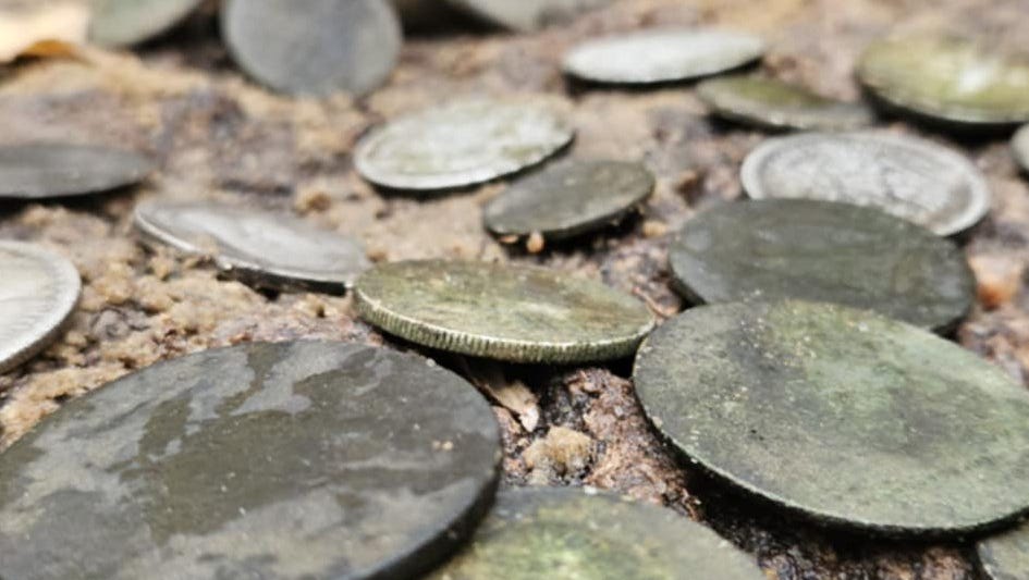 Poland archaeologists uncover ancient coins, artifacts in WWII grave