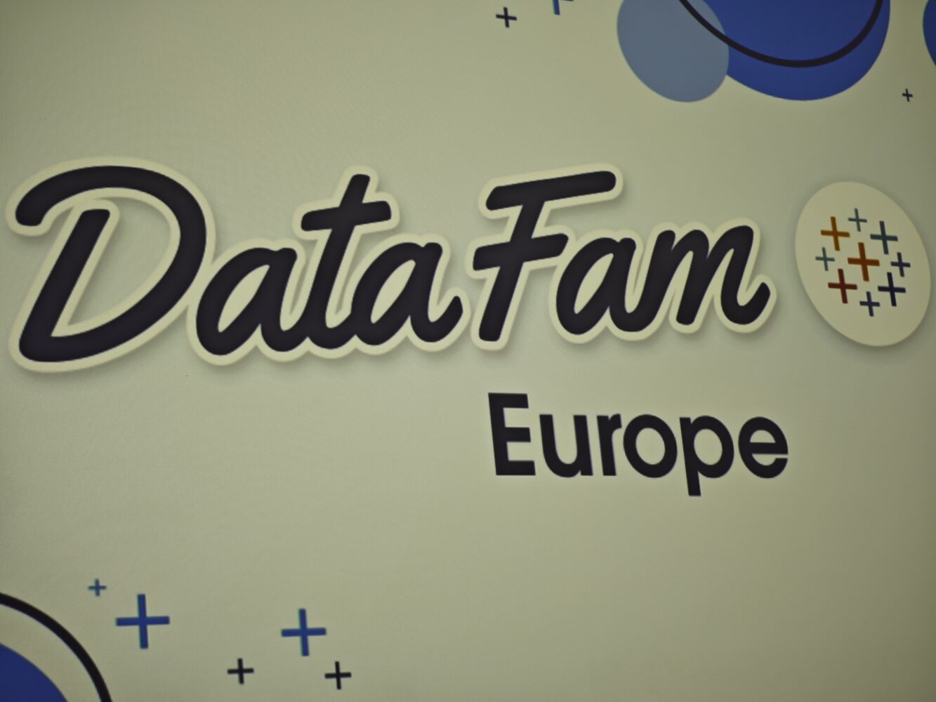 Bord met de tekst "Data Fam Europe" met abstracte blauwe en grijze designelementen.