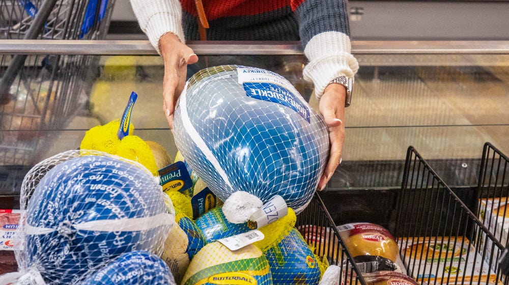 A shopper picks up a frozen turkey at a Walmart.