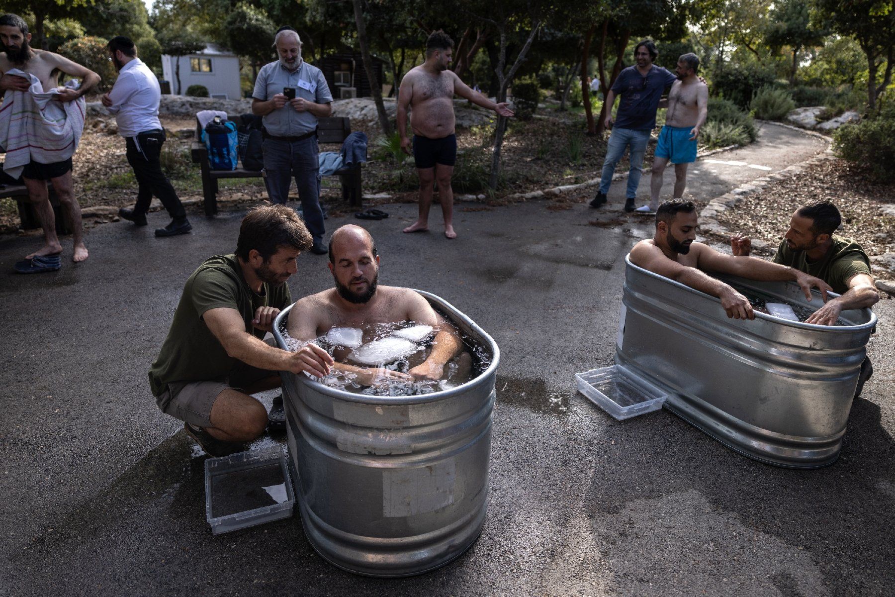 Des volontaires de Zaka s'immergent dans des baignoires métalliques remplies d'eau froide et de blocs de glace, lors d'une session d'activités visant à traiter les traumatismes, à Nes Harim, près de Jérusalem, le 17 novembre 2024