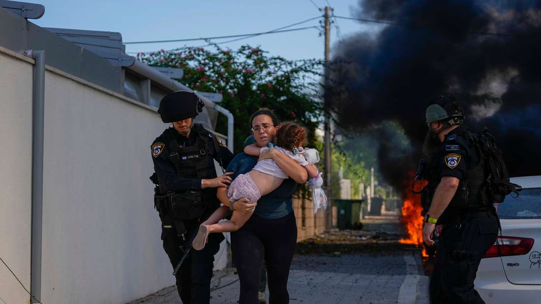 Israelische Polizisten evakuieren Frau und Kind im Israel Krieg 