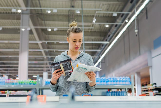 A woman buying frozen food from a supermarket.