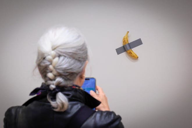 A journalist takes a picture of Italian visual artist Maurizio Cattelan's duct-taped Banana entitled "Comedian," on Nov. 8, 2024.