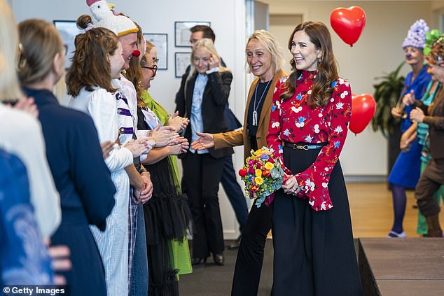 Mary was greeted by workers who were dressed in colourful outfits with balloon headwear and round clown noses