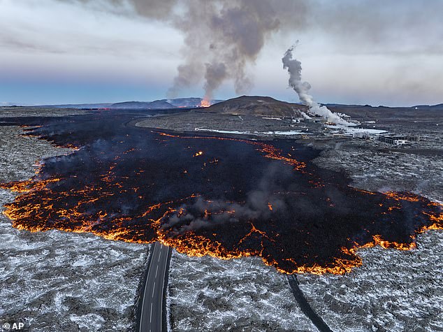 Lava pictured flowing across one of the roads near Grindavik on Thursday morning