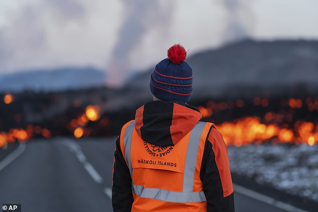 A scientist from the University of Iceland observes lava flowing on Thursday morning