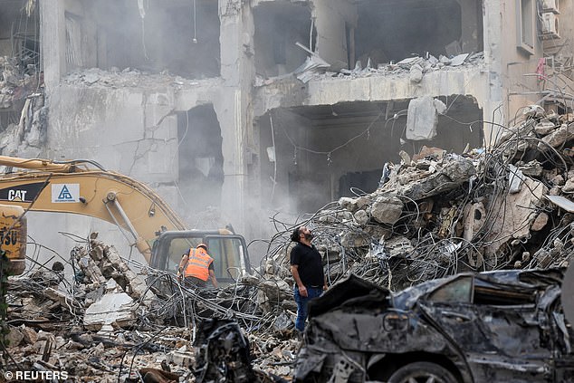 Civil defense members and rescuers work at the site of an Israeli strike in Beirut's Basta neighbourhood