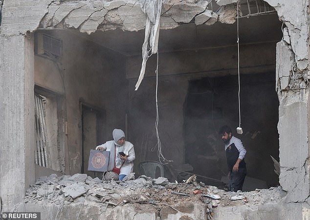 People search for their belongings inside a damaged building in the aftermath of an Israeli strike in Beirut's Basta neighbourhood