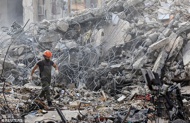 A civil defense member walks among the debris at the site of an Israeli strike in Beirut's Basta neighbourhood