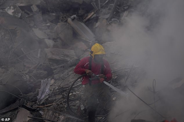 A firefighter extinguishes a fire at the site of an Israeli airstrike that hit central Beirut