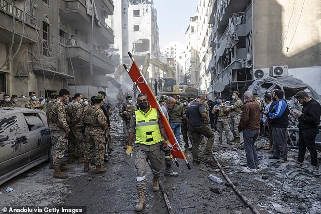 Lebanese civil defense teams and soldiers conduct search and rescue operations among the rubbles of a collapsed eight story building