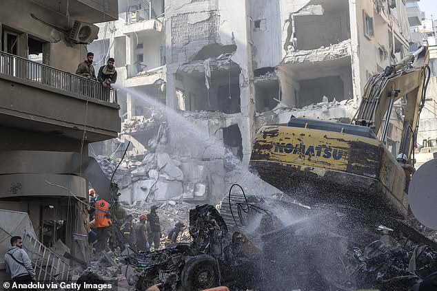 Lebanese civil defense teams and soldiers conduct search and rescue operations among the rubbles of a collapsed eight story building