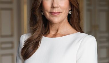Queen Mary is seen posing in an elegant boat-neck cream dress and diamond earrings - with a delicate 'F' necklace around her neck