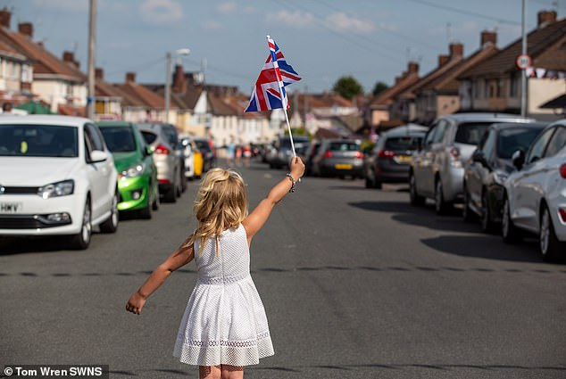 Poppie Stacey, four, is seen waving a Union flag during 75th anniversary celebrations marking VE Day in May 2020
